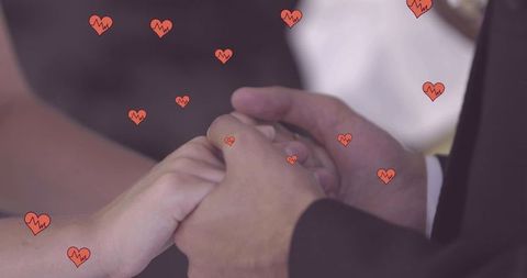 Newlywed Couple Holding Hands with Romantic Hearts