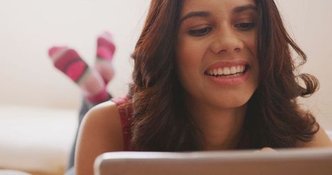 Woman Relaxing at Home Smiling and Using Digital Tablet