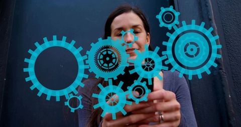 Woman interacting with smartphone showing augmented blue gears overlay for app control