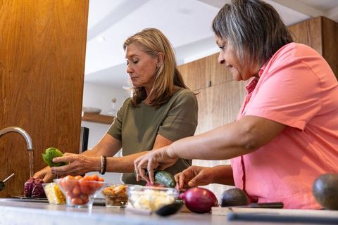 Mature Women Cooking and Preparing Fresh Vegetables in Modern Kitchen