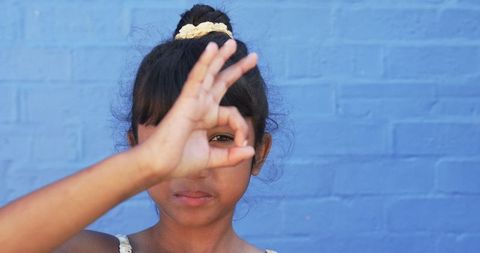 Young Girl Making Gesture Over Blue Background