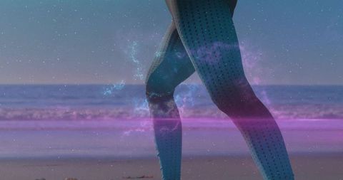 Surreal twilight beach legs wearing turquoise leggings wading through magenta nebula light