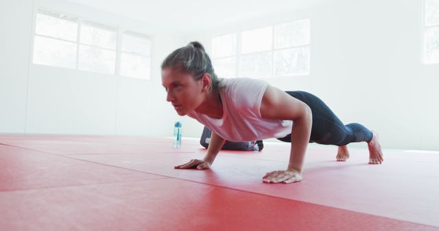 Determined Woman Practicing Push-ups in Yoga Studio - Download Free Stock Images Pikwizard.com