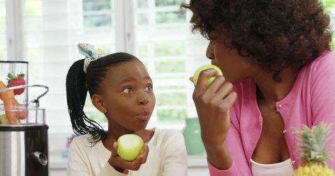 Mother and Daughter Enjoying Healthy Snack in Kitchen