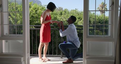 Romantic proposal on balcony with lush greenery