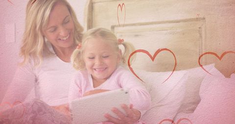 Mother and Daughter Smiling with Tablet and Heart Graphics