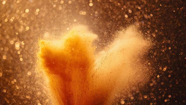 Abstract golden powder explosion with sparkling bokeh effects