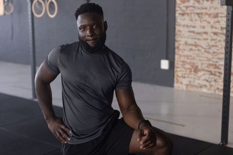 African american man kneeling and resting after intense training in industrial gym