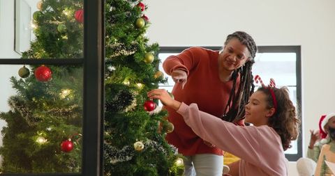 Family celebrating christmas by decorating christmas tree together