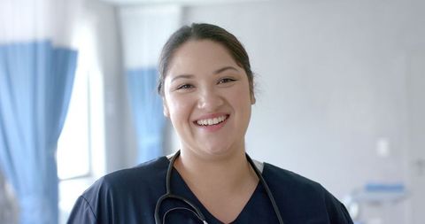 Smiling Female Doctor in Hospital Ward with Stethoscope