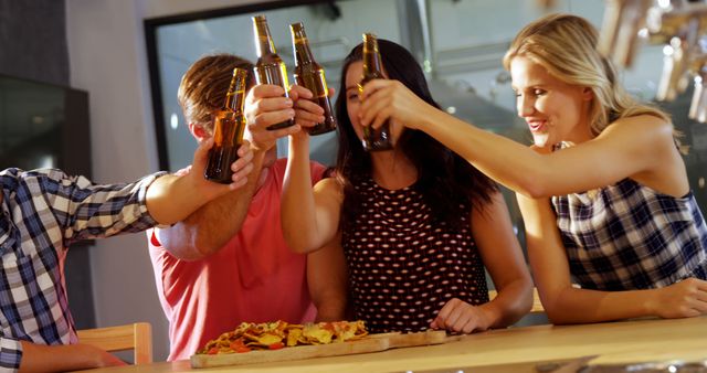 Group of Friends Clinking Beer Bottles in Celebration at Bar - Download Free Stock Images Pikwizard.com