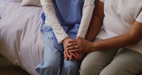 Senior woman comforted by doctor in retirement home