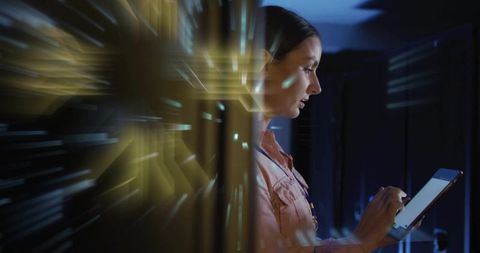 Female technician using tablet in data center with circuitry light trails and led servers