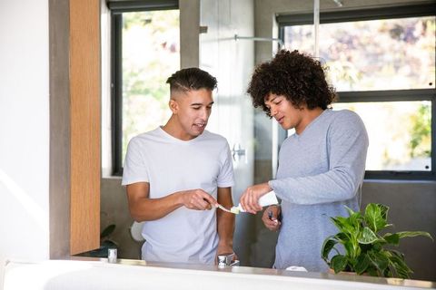 Diverse Friends Brushing Teeth Together in Modern Bathroom