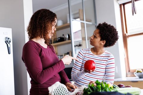 Diverse Lesbian Couple Unpacking Groceries in Bright Kitchen