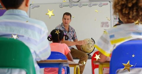 Elementary teacher holding globe teaching world geography while students listen in bright classroom
