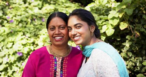 Smiling Indian Mother and Daughter Enjoying Quality Time in Lush Garden