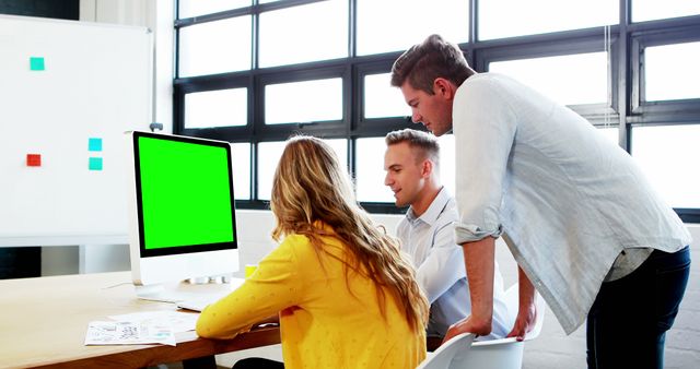 Team Collaborating on Project in Modern Office with Green Screen Monitor - Download Free Stock Images Pikwizard.com