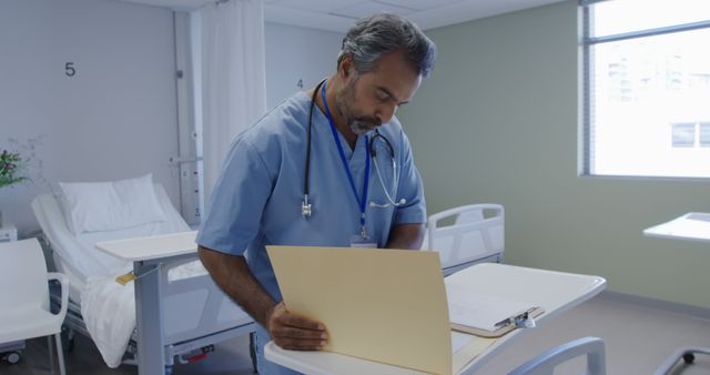 Doctor reviewing patient files in hospital ward - Download Free Stock Images Pikwizard.com