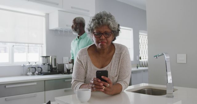 Elderly Woman Using Smartphone in Modern Kitchen - Download Free Stock Images Pikwizard.com