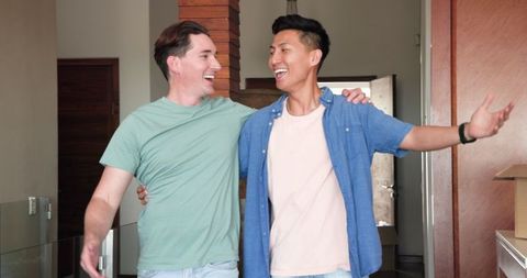 Diverse Male Couple Reuniting Happily in New Home, Bonding Moment