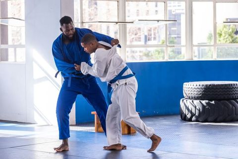 Men practicing judo techniques in modern studio