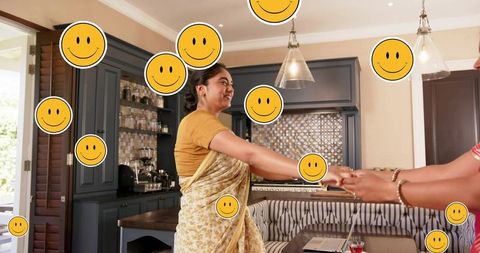 Indian woman in saree holding hands in modern kitchen with laptop and smiley stickers