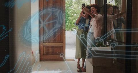 Young women taking selfie at front door with augmented reality circuit hologram overlay