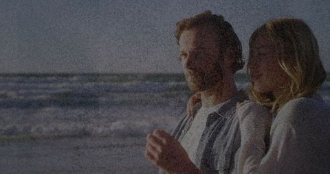 Romantic Couple Embracing on Sunny Beachfront with Waves