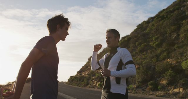 Senior caucasian father and adult son running, stretching by road and talking at sunset - Download Free Stock Photos Pikwizard.com