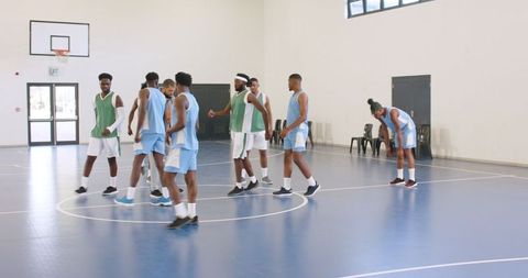 Diverse Basketball Team Discussing Strategy on Indoor Court