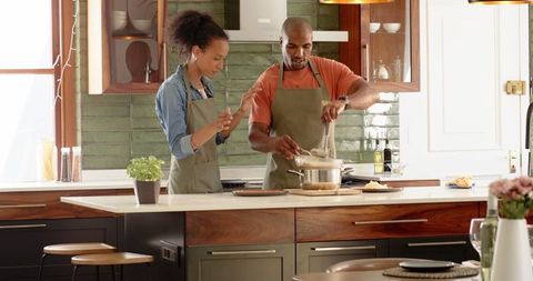Couple cooking together in modern kitchen with teamwork and focus