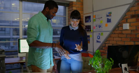 Colleagues Analyzing Data on Tablet in Modern Office