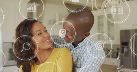 Romantic couple embracing in modern kitchen with digital icons