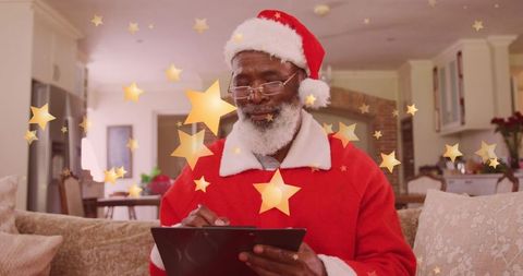 Festive African American Man in Santa Suit Using Tablet