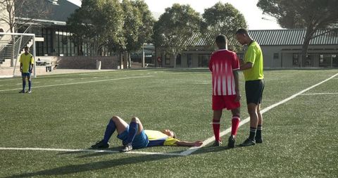 Referee checking injury during intense soccer match