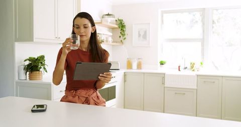 Young Woman Using Tablet in Bright Modern Kitchen
