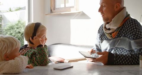 Father and children enjoying quality time at home with tablet