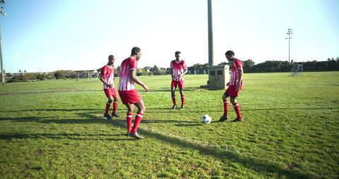 Soccer players practicing on field in team uniforms