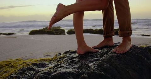 Romantic Couple Standing on Beach Rock During Sunset - Download Free Stock Images Pikwizard.com