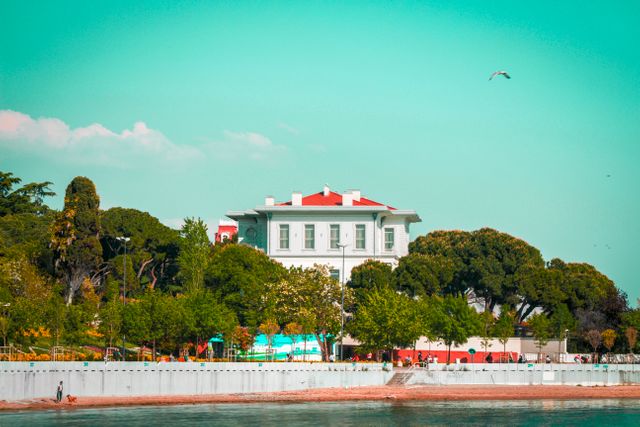 Historic Waterfront Mansion with Lush Greenery under Blue Skies - Download Free Stock Photos Pikwizard.com