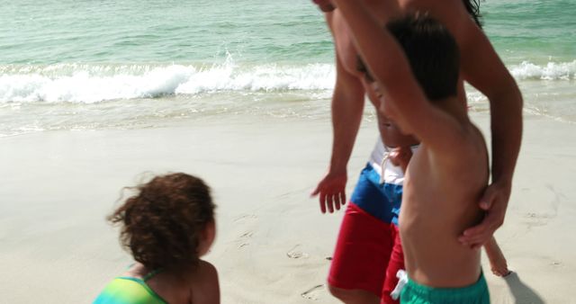 Father playing with children on sandy beach by ocean waves - Download Free Stock Images Pikwizard.com