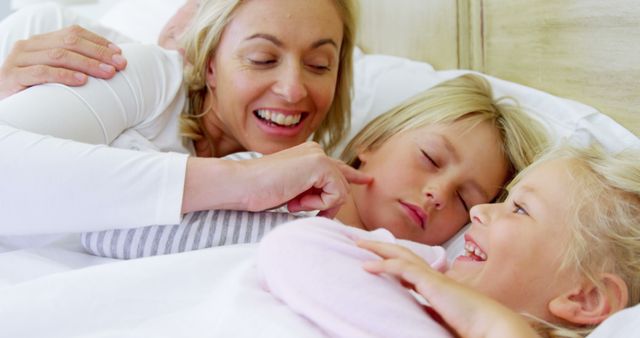 Happy Mother Cuddling Children in Bed for Quality Time in Morning - Download Free Stock Images Pikwizard.com