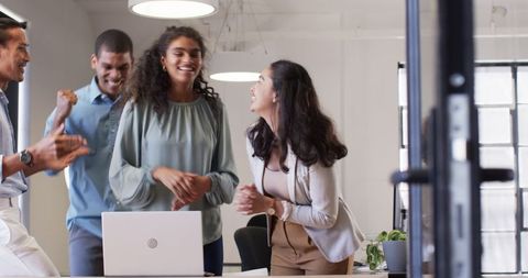 Team celebrating success in office, multiracial coworkers clapping