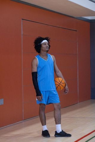 Confident Basketball Player on Indoor Court Preparing for Game