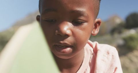 Boy Reading Book in Park Enjoying Outdoor Learning