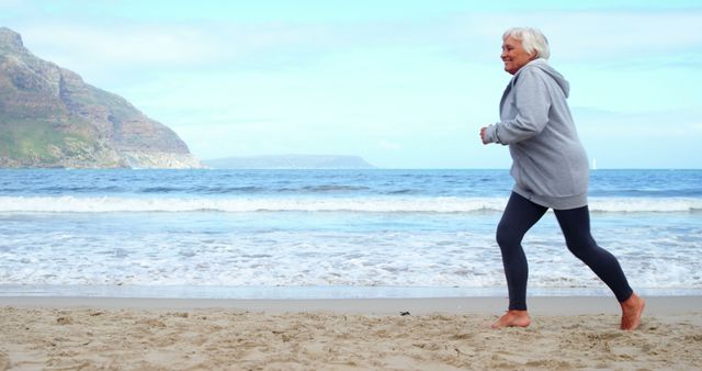 Senior Woman Jogging on Beach Near Ocean - Download Free Stock Images Pikwizard.com