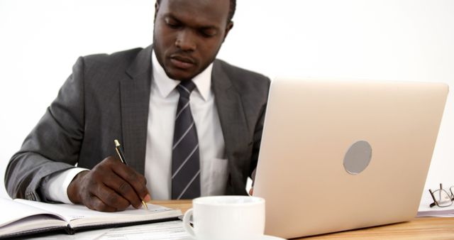 Focused Businessman in Suit Working at Desk with Laptop and Documents - Download Free Stock Images Pikwizard.com