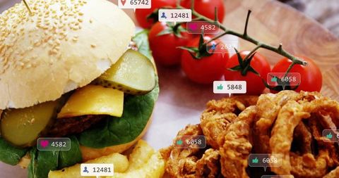 Cheeseburger sitting on sesame bun with crinkle fries, onion rings and social media likes