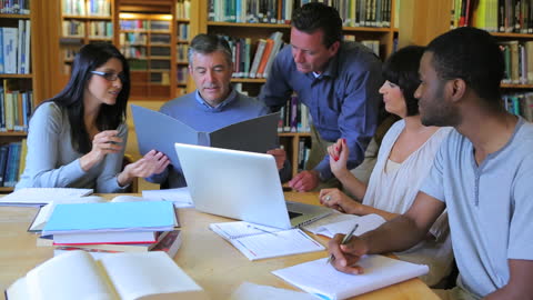 Diverse Group of Adult Students Collaborating in Library